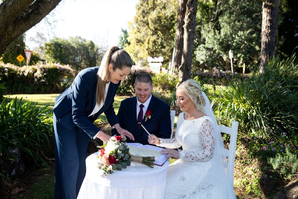 Karen Miles Wedding Celebrant Tamborine Mountain with couple signing paperwork